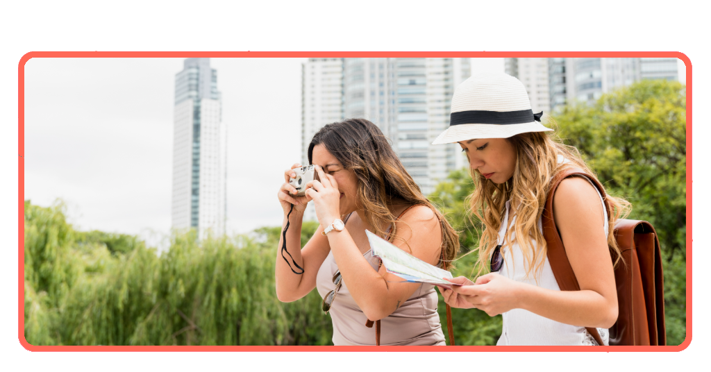 Mujeres jóvenes planificando viaje con mapa y cámara